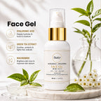 A bottle of Buttr Tr Face Gel SPF 30 with a white body and gold pump collar, styled on a marble tray with green leaves, white flowers, and glass droplets against a bright, softly lit background.